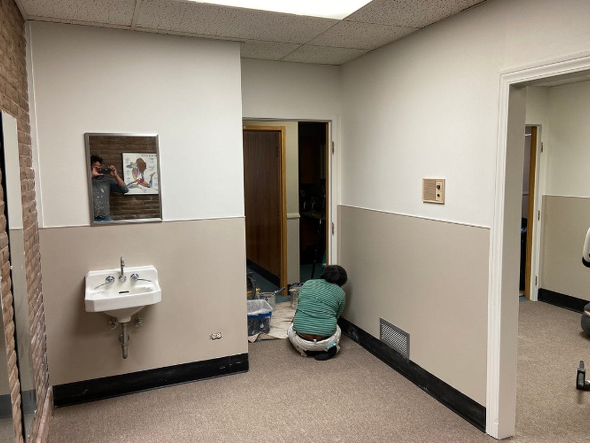 Clinic room being repainted, with fittings masked and floors covered
