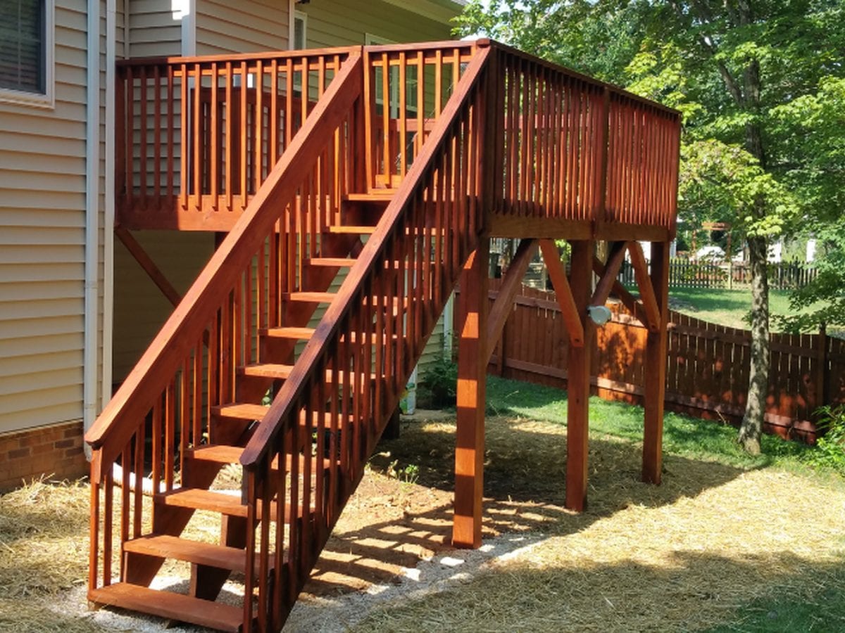 Elevated deck and stair structure stained a warm red-brown