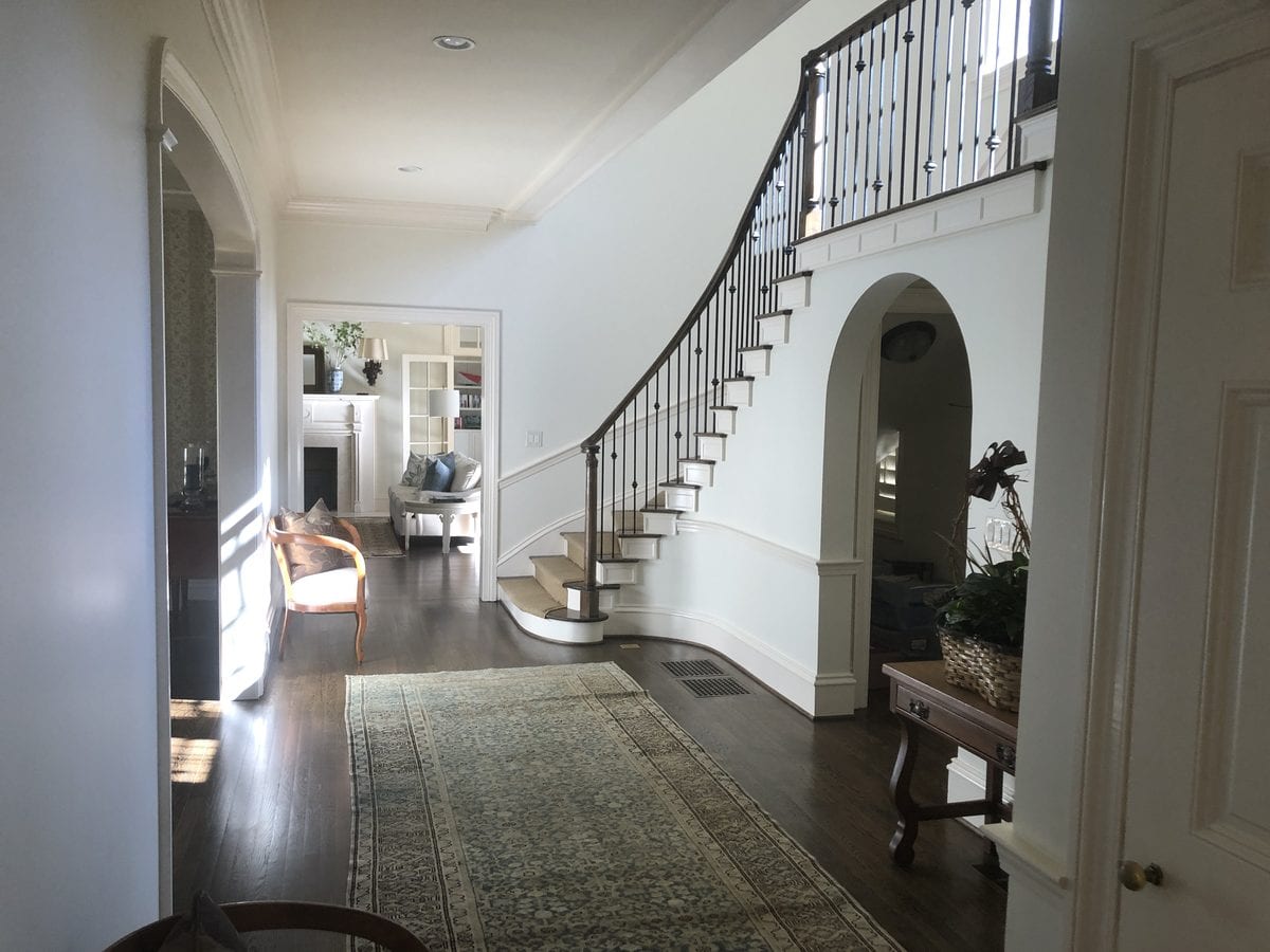 Two-storey entry hall and curved staircase after interior repainting
