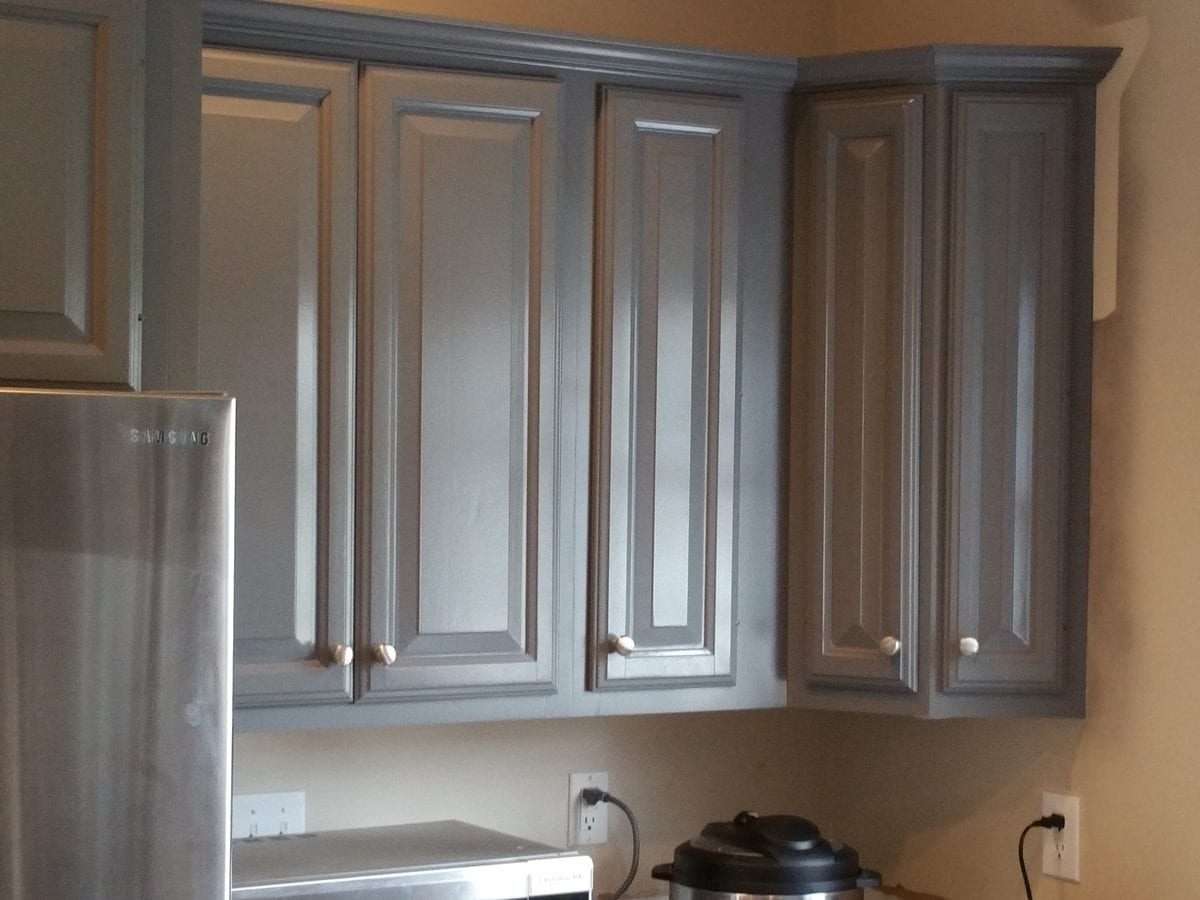 Kitchen cabinets refinished in grey beside stainless appliances