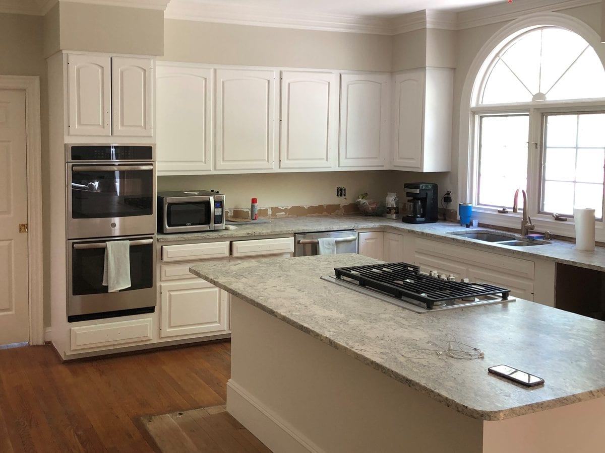 Kitchen with repainted cream cabinets, crown moulding and trim